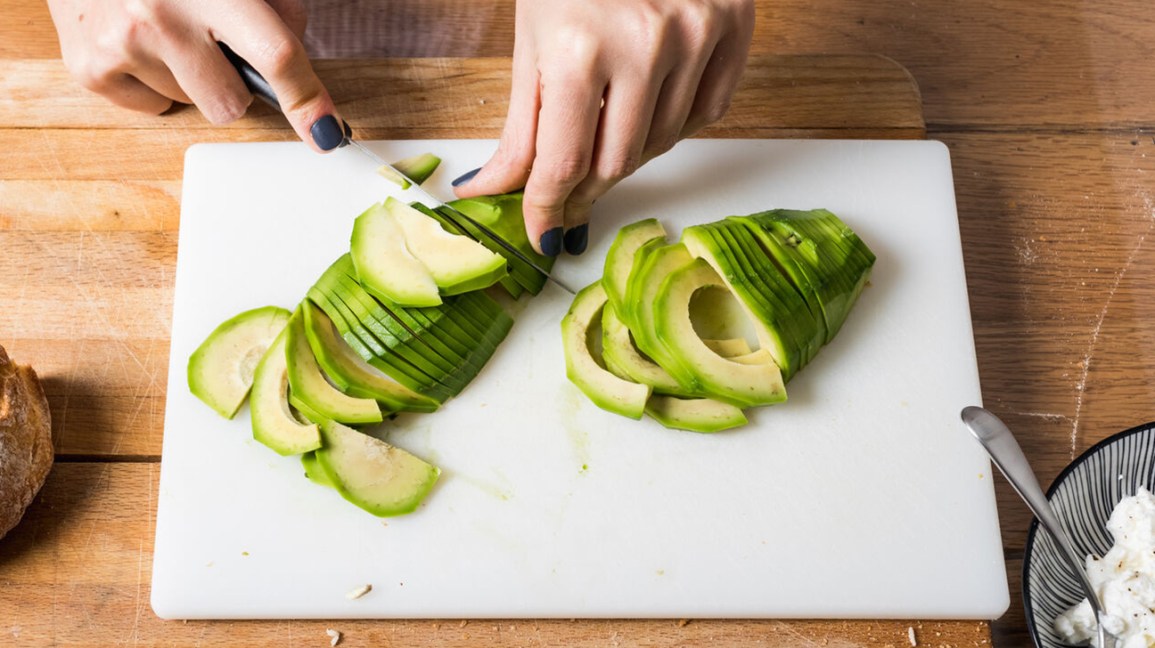 rebanar aguacates en una tabla de cortar